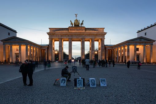 Artists and tourists in front of the Brandenburg Gate.