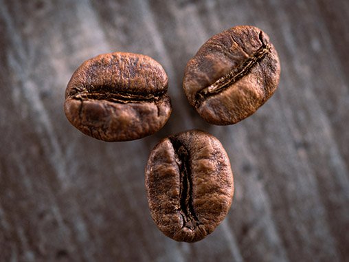 A macro shot of three coffee beans.