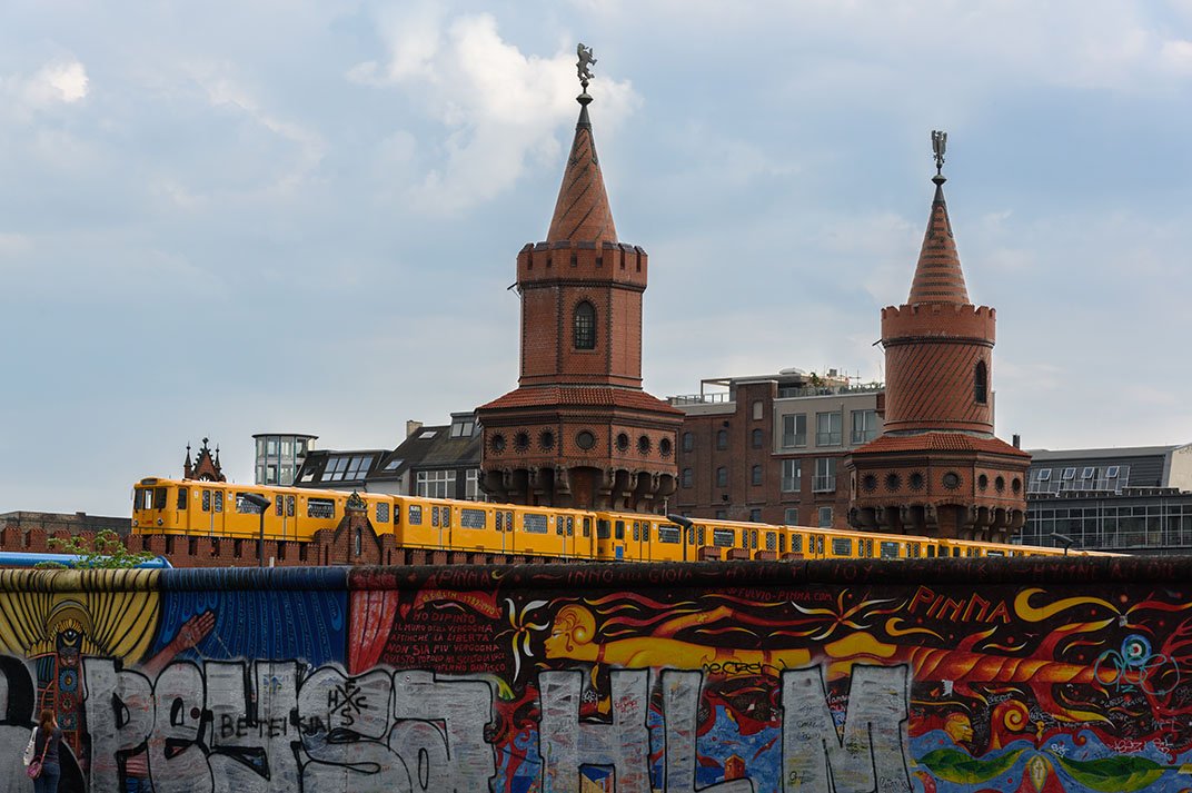 Behind the East Side Gallery, a U-Bahn crosses the Oberbaumbrücke.