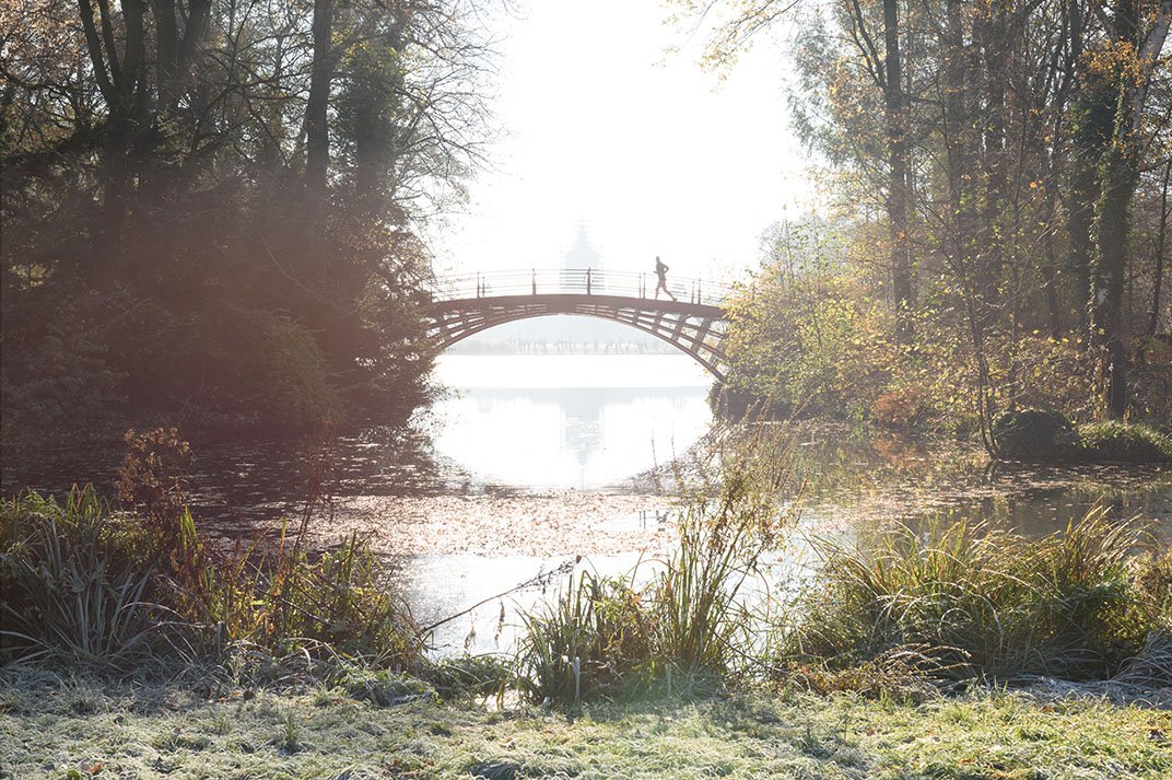 A runner crosses a bridge in Schlosspark Charlottenburg.
